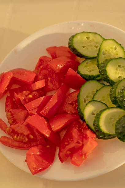 istock Fresh chopped tomatoes and cucumbers on a white plate 1338532382