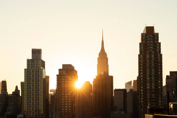 City Sunset Sunset behind skyscraper buildings in New York City. queens new york city stock pictures, royalty-free photos & images