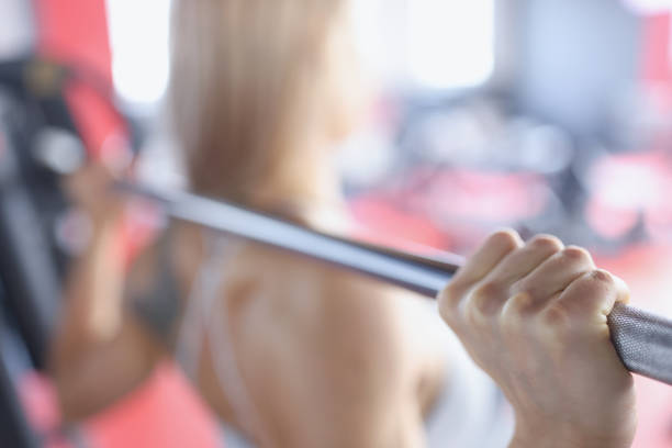 istock Back view of woman doing exercises with barbell 1338538794