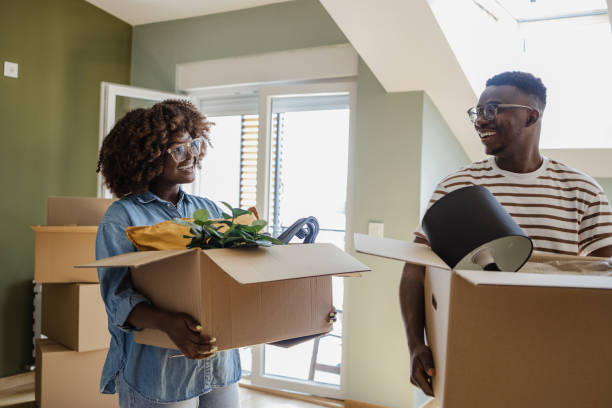 istock Couple carrying boxes into new home on moving day 1338541170