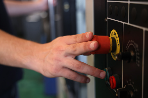 Male Operator use hand to push emergency button
