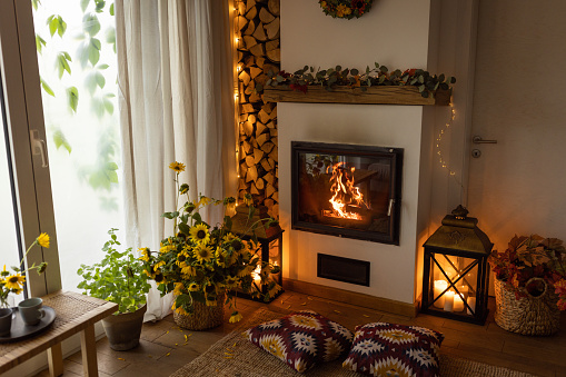 Comfortable arranged cottage with fireplace. Autumn theme interior details.
