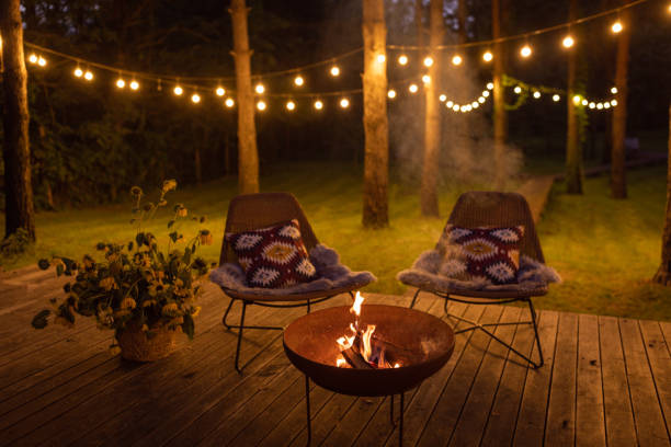 Fire pit at cottage Comfortable arranged porch with fire pit and chairs. Autumn theme details. String lights in the background. fire pit photos stock pictures, royalty-free photos & images