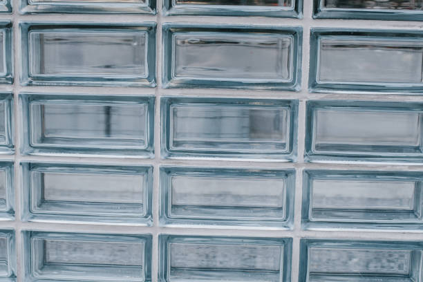 istock Closeup Glass block wall for background. Abstract design of light through. Isolated light transparent square mirror glass block cube 1338555853