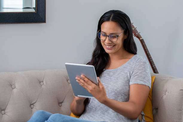 istock Woman uses digital tablet in living room while working from home 1338571207