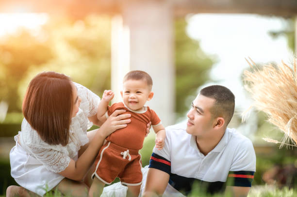 happy young asian family spending time outdoor the summer holiday. happy young family spend time outdoor in garden during the summer holiday. - vacations women men stability imagens e fotografias de stock