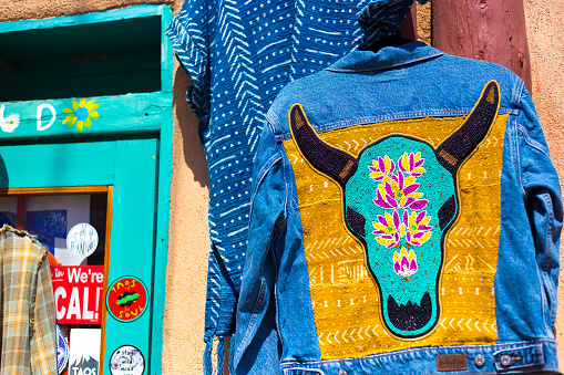 Taos, NM: A Southwest-style jean jacket hangs outside a shop in historic downtown Taos.