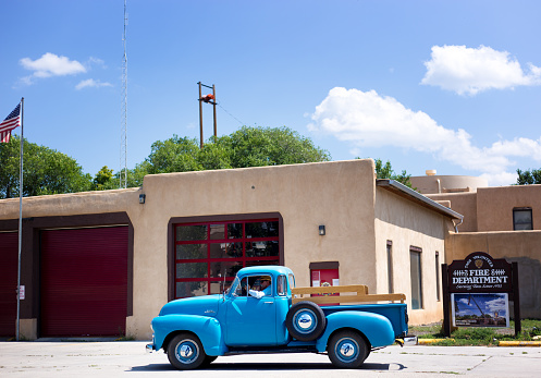 Taos, NM: A vintage turquoise pickup truck stopped in front of the Taos Fire Station.