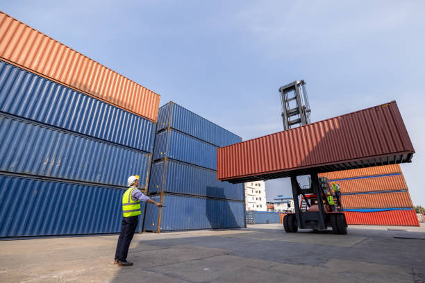 istock American man Foreman control loading containers box to truck for logistics export of International global shipping. Thailand 1338591946