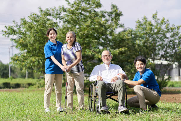 anziani e caregiver che fanno una passeggiata - nursing home senior adult group of people home caregiver foto e immagini stock