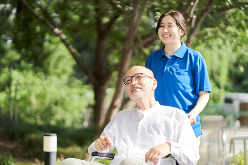 Female caregiver supporting the elderly in wheelchairs