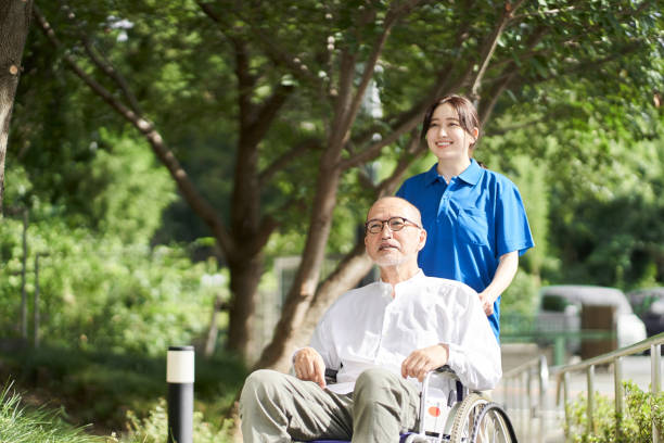 istock Female caregiver supporting the elderly in wheelchairs 1338601080