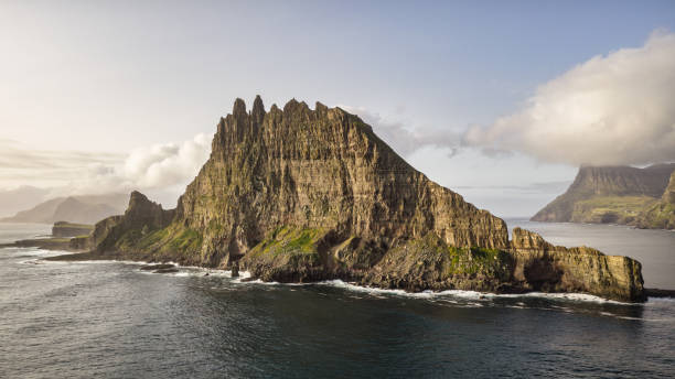 Faroe Islands Tindholmur Rock Island Panorama Tindhólmur Vágar Island Faroe Islands Tindhólmur Rock Islet in the North Atlantic Ocean under summer cloudscape. Mid-Air Drone Point of view Panorama towards the harsh steep rock formation. Tindholmur Island close to Vágar Island on the southside of Sørvágsfjørður. Faroe Islands, Denmark, Nordic Countries, Europe vágar photos stock pictures, royalty-free photos & images