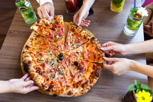 istock Above view of unrecognizable people having pizza in a restaurant. 1338609465