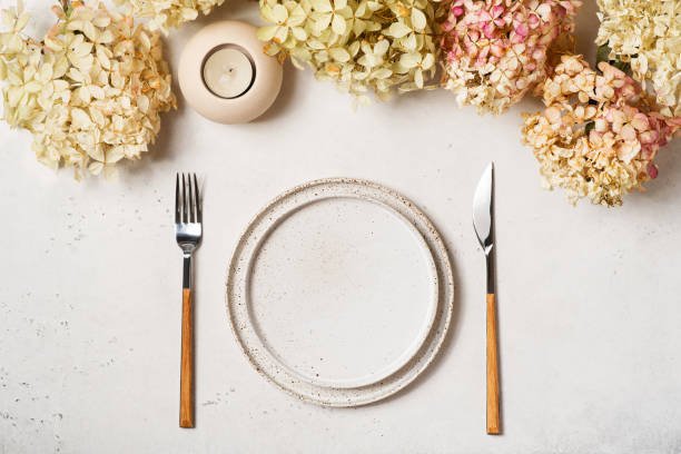 istock Thanksgiving table setting with dry flowers, plate, tableware and candle on white background 1338610791