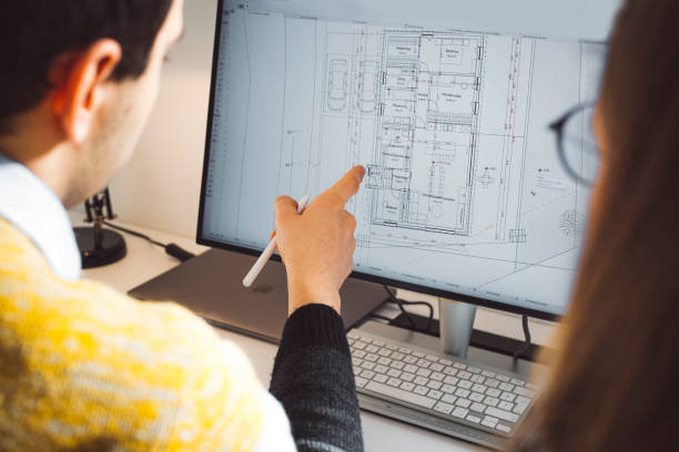 istock Over the shoulder view - Architects going over house plans 1338615777