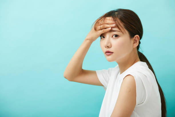 注射を受けた若いアジア人女性。 - 頭がぼーっとする 日本人 ストックフォトと画像