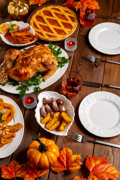 istock Thanksgiving Day table with turkey, pumpkin pie, roasted vegetables, top view. Thanksgiving dinner and autumn decoration. 1338619904