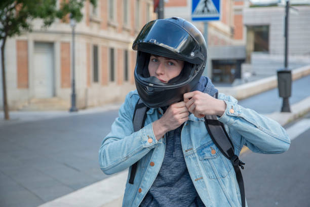 istock young man riding a motorcycle putting on helmet in city 1338619949