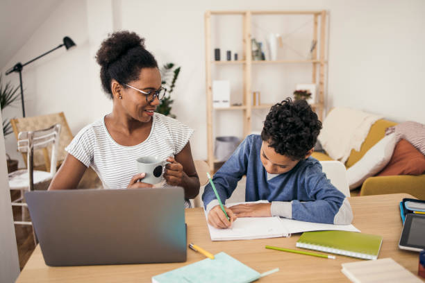 istock African-American woman working and helping her boy with homework 1338623032