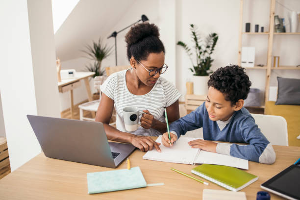 istock African-American boy doing homework with the help of his mom 1338623033