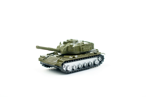 Model toy of battle tank with a barrel ready to fire. War concept. Military pancer on the gray background. Macro shot.