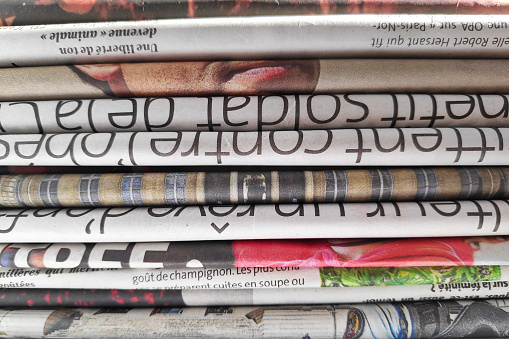 Close-up on a stack of French newspapers.
