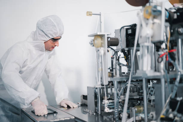istock Scientists wearing protective clothing Inspect mask making machines in a laboratory at an industrial plant. Anti-virus production warehouse. concept of safety and prevention coronavirus covid-19. 1338632697