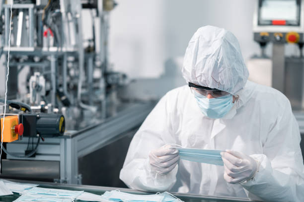 istock Scientists wearing uniform protection. Check the manufacturing process of face masks. In a laboratory at industry plants. The concept for security and protection coronavirus covid-19. 1338632961