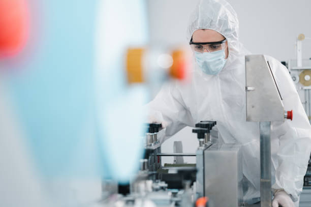 istock Scientists wearing protective clothing Inspect mask making machines in a laboratory at an industrial plant. Anti-virus production warehouse. concept of safety and prevention coronavirus covid-19. 1338632983