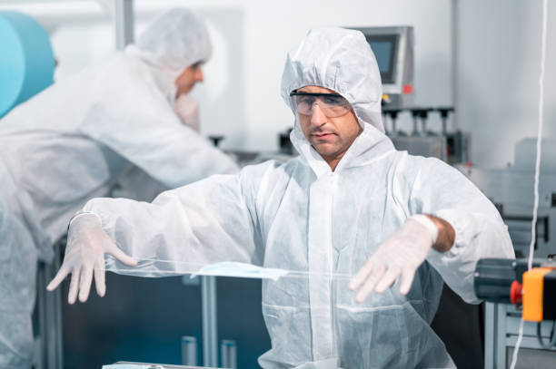 istock Scientists wearing uniform protection. Check the manufacturing process of face masks. In a laboratory at industry plants. The concept for security and protection coronavirus covid-19. 1338633031
