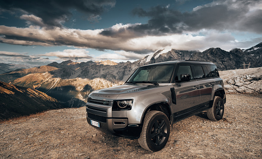 Passo dello Stelvio, Italy - August 27, 2021 : The New Land Rover Defender against the alps at Passo dello Stelvio close to Bormio