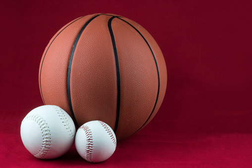 Softballs and basketball isolated on a red background
