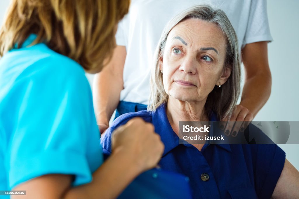 Worried senior woman talking with nurse Depressed elderly woman talking with nurse. Close up of face. Human Face Stock Photo
