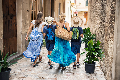 Tourist family walking in streets of Spanish town, Majorca, Spain.\nShot with Canon R5.