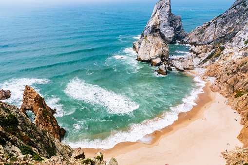 Ocean waves crashing onto rocky cliffs in Cabo da Roca - the westernmost point of the European continent.