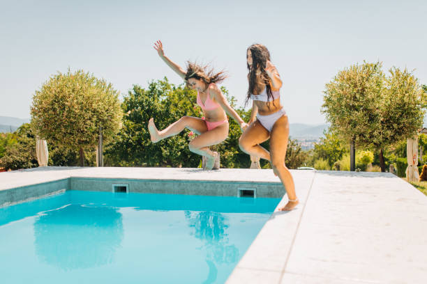 istock Two friends have fun and jump in the pool 1338641810