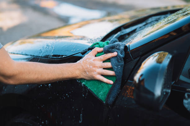 istock The guy wipes the car with soap rag 1338643805