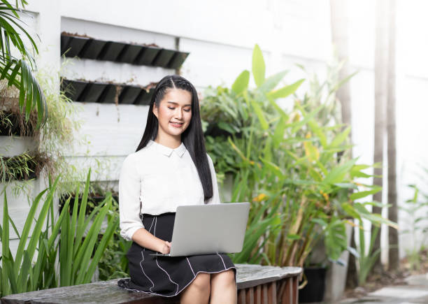 istock Beautiful young asian woman working with computer notebook while sitting outside the office. Social distancing concept. 1338645610
