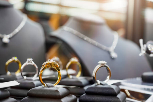 anillos de diamantes de joyería de oro se muestran en escaparates de tiendas minoristas de lujo - colección fotografías e imágenes de stock