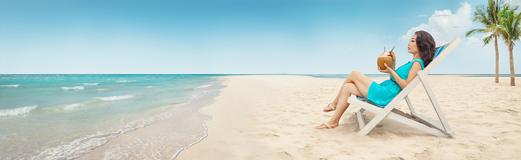 Young woman relaxing on the tropical beach. Wide panoramic horizontal photo