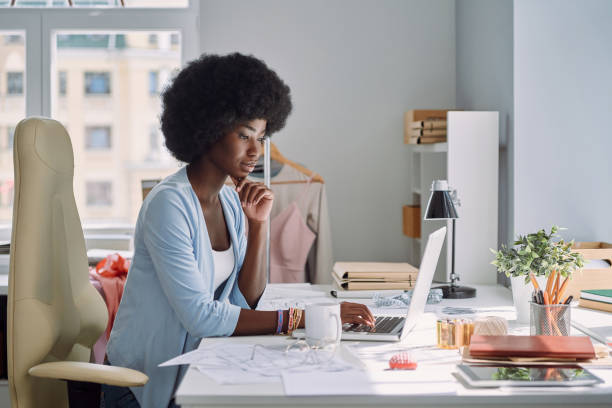 istock Beautiful young African woman using laptop 1338655034