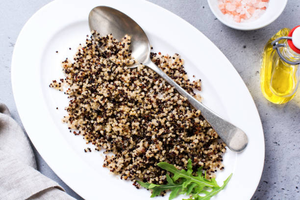 istock Cooked white, red and black quinoa in white plate on grey rustic background, top view, place for text recipes or menu. Vegan Superfood, healthy eating and nutrition or diet concept. 1338655913