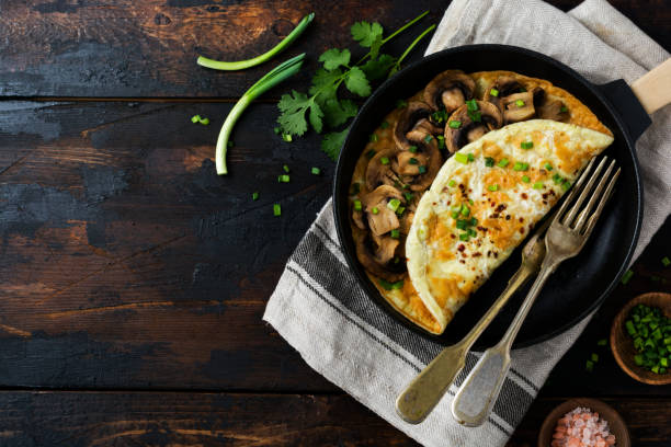 istock Fresh Scrambled Egg, omelette or frittata with mushrooms, onions and fresh herbs on cast iron skillet. Top view with copy space. 1338656426