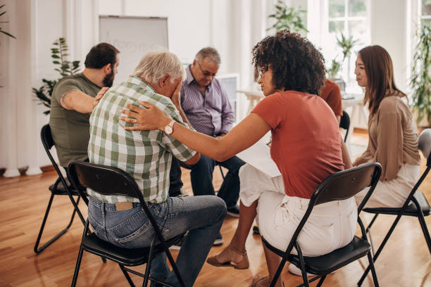 istock People consoling man at group therapy 1338658644