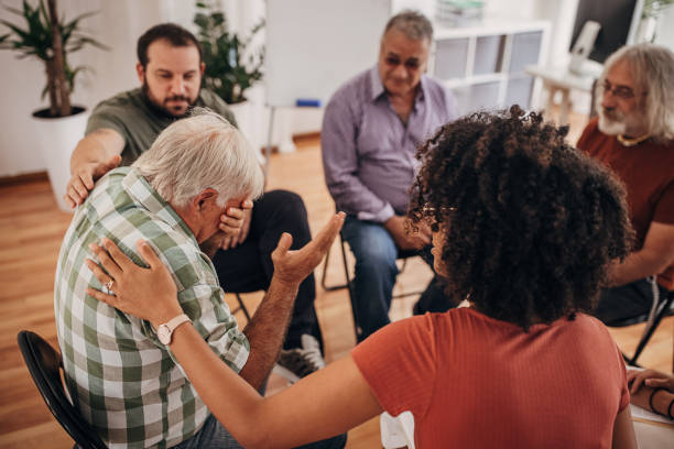 istock People consoling man at group therapy 1338658779