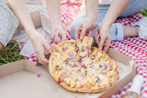 istock Young couple having picnic eating pizza 1338659636