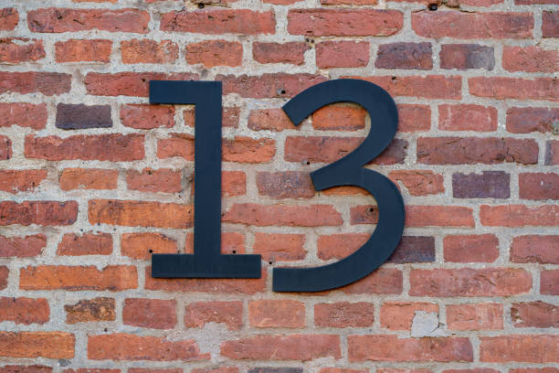 istock House number thirteen (13) on a red brick wall. 1338661070