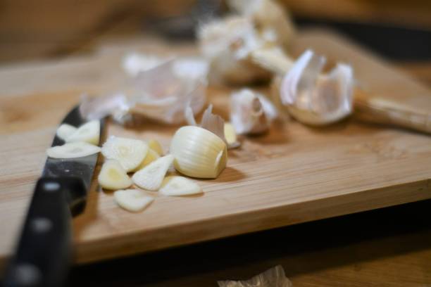 istock Garlic being chopped on a wooden chopping board 1338661903