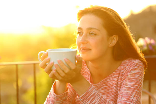 istock Woman contemplating with coffee mug at sunset 1338662762